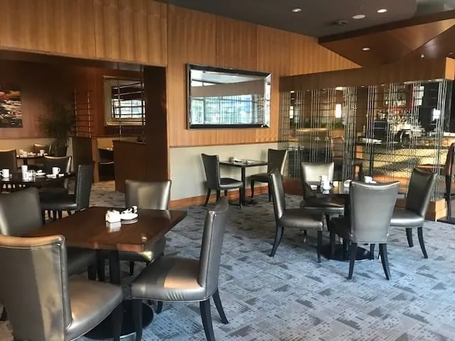 Dining room with leather chairs and wood-panelled walls at The Edge Social Grille and Lounge