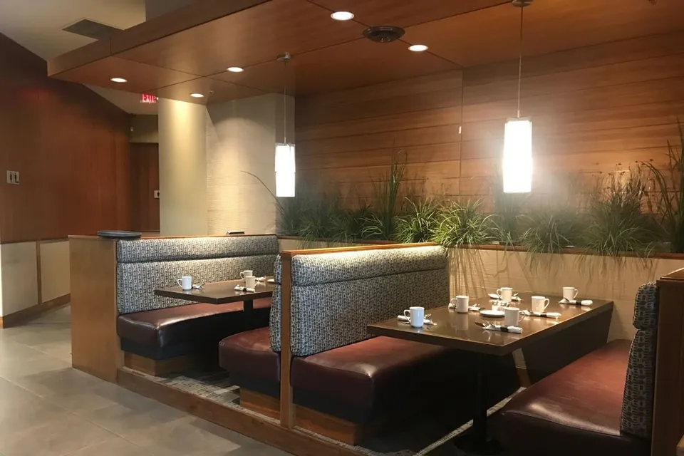 Booth seating with wood paneling and pendant lighting at The Edge Social Grille and Lounge