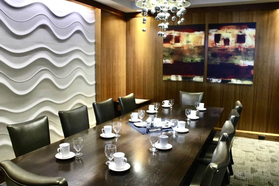 Cambie Room at Chateau Granville, the sculpted wave wall and paired artwork above a single long table