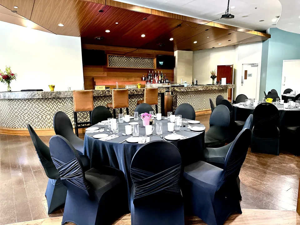 Capilano Room at Chateau Granville — round banquet tables beside the room's fully stocked bar