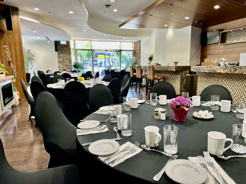 Capilano Room at Chateau Granville — banquet tables and the marble bar with leather stools, lit by Granville Street windows