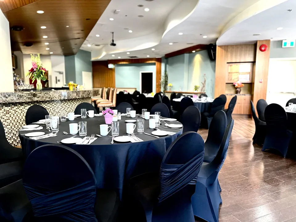 Capilano Room at Chateau Granville — a round table set with place settings beside the bar and teal feature walls