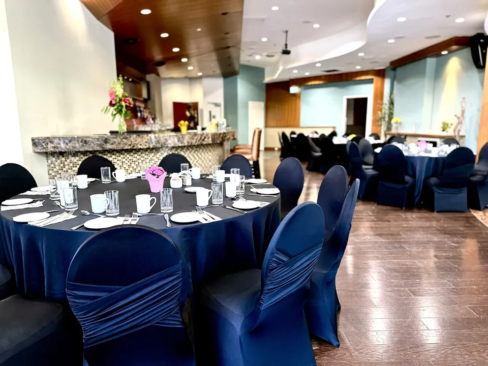 Capilano Room at Chateau Granville — banquet seating beneath the curved ceiling, with the bar and teal feature walls
